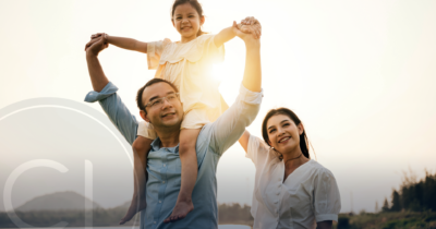 Happy Asian family outdoors at sunset, symbolizing financial freedom and global mobility through second citizenship